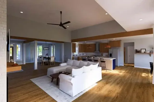 Primary suite with vaulted ceiling, exposed beams, and rear-facing glass to screened porch