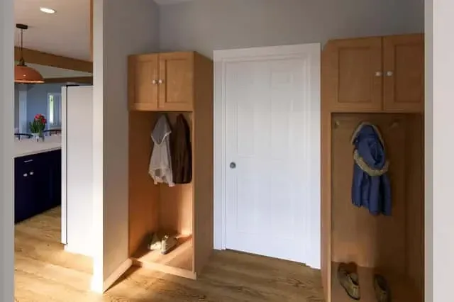 Mudroom with built-in lockers, bench seating, and tile floor between garage and kitchen