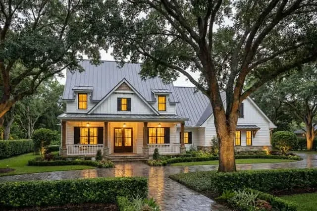 Front approach to Plan 16919WG Country Craftsman facade showing paved walkway landscape hedges and front veranda with exposed Douglas fir timber rafter tails