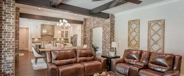 Mudroom with built-in white painted lockers, tongue-and-groove bench seating, Amba Antus towel warmer hooks, and herringbone tile floor connecting the garage entry to the main living area