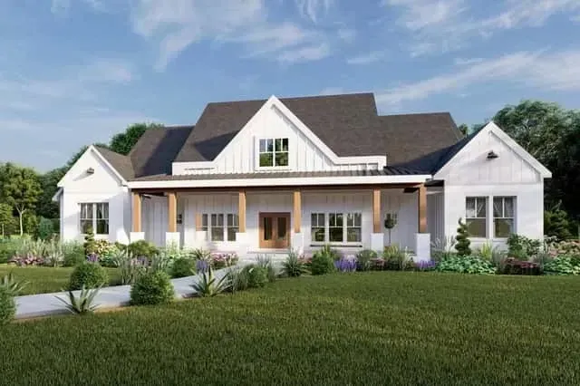 Evening rendering of the front elevation showing porch lighting, landscape uplighting on the stone veneer, and illuminated gable windows