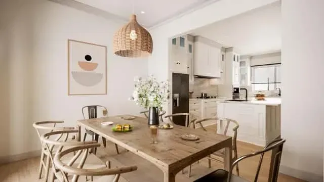 Dining area adjacent to the kitchen with farmhouse-style trestle table, upholstered parson chairs, and a black linear chandelier