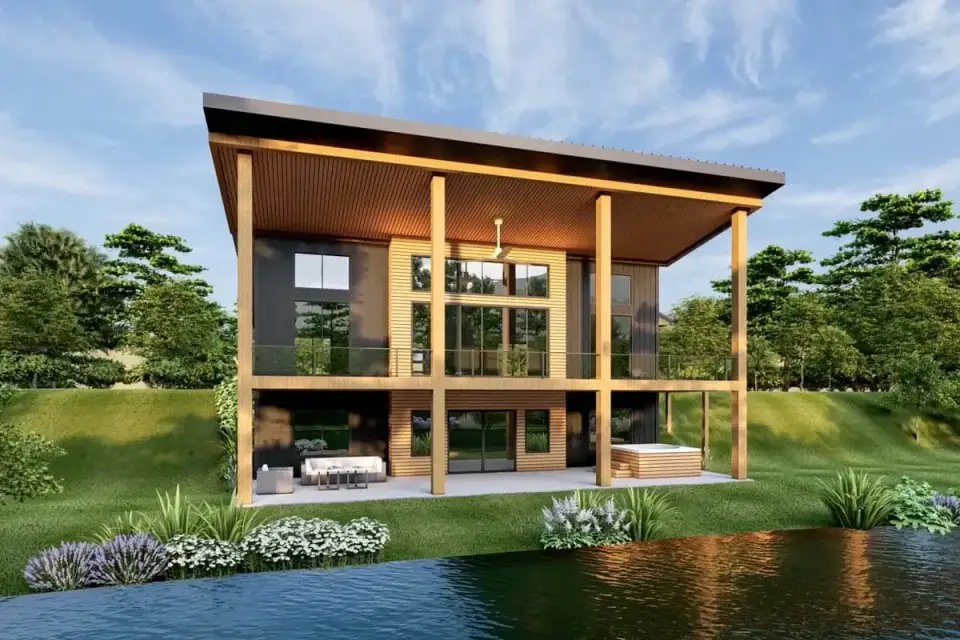 Plan 135233GRA dusk exterior with warm interior lighting glowing through black framed window wall on rear elevation deck illuminated by post lighting and forest setting