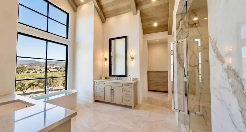 Primary bathroom with freestanding tub, glass-enclosed shower, and dual vanities