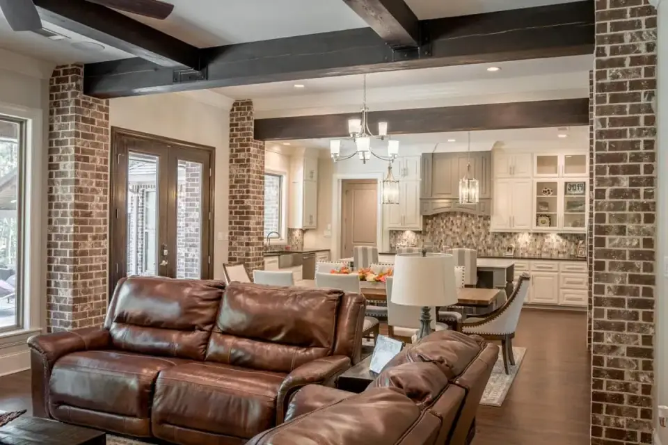 Home office of Plan 51814HZ near the foyer showing a custom built-in desk, bookshelves flanking the window, wood beam ceiling detail, and natural light from a front-facing window