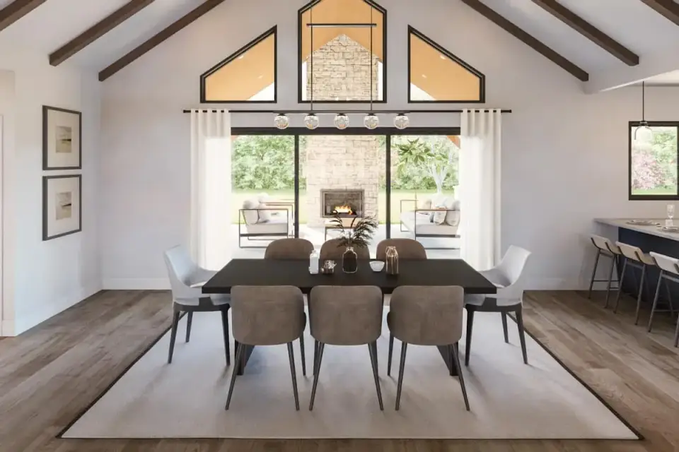 Dining area between the kitchen and great room with vaulted ceiling, wood beams, and a pendant light fixture