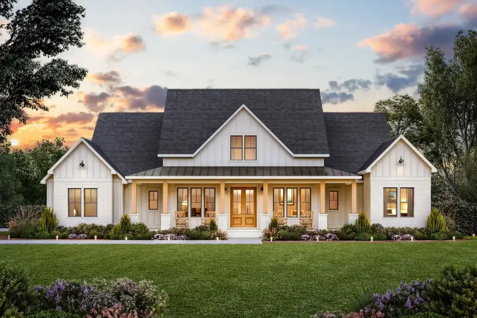 Front elevation of the modern farmhouse with white board-and-batten siding, stone veneer base, timber-framed porch columns, and standing-seam metal accent roof over the covered porch
