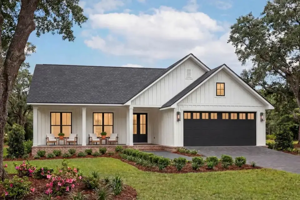 Front elevation of Plan 52037HZ 1523 sq ft modern farmhouse with white board-and-batten siding, gabled roofline, front covered porch with square columns and side-entry two-car garage