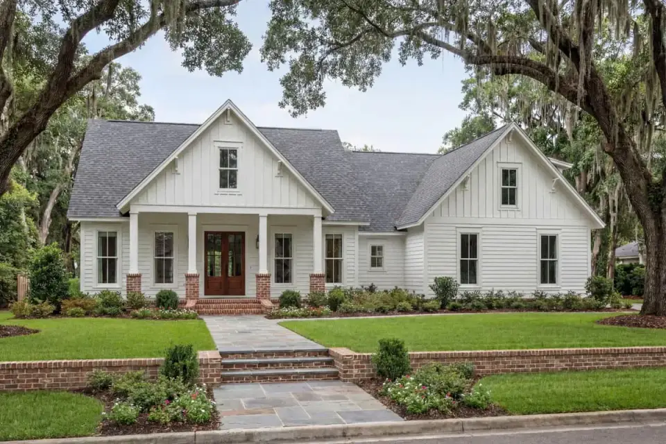 Opposite side elevation showing the primary suite wing, exterior chimney detail, and landscaping