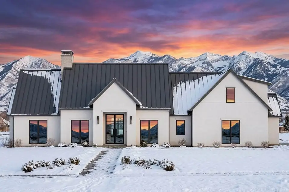 Winter rendering of plan 818204JSS with snow on the standing-seam metal roof and white stucco walls