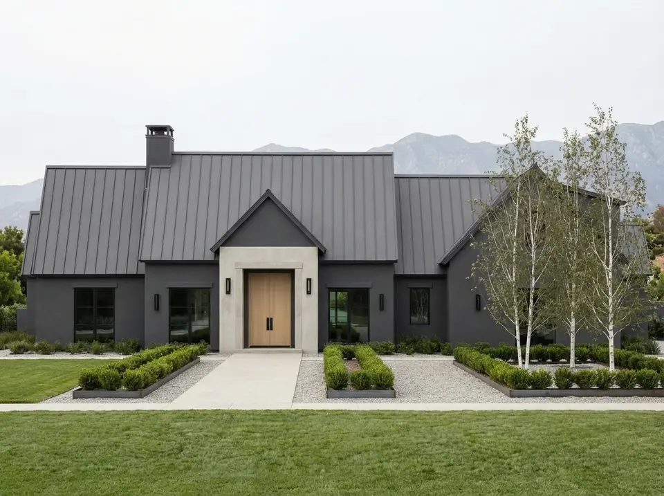 Charcoal modern facade of plan 818204JSS with charcoal stucco and roof, pale concrete entry surround, pale oak door and silver birches