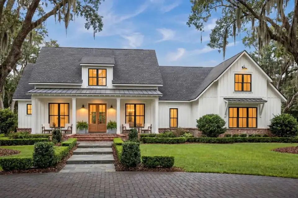 Modern farmhouse exterior with white board and batten siding and metal roof accent