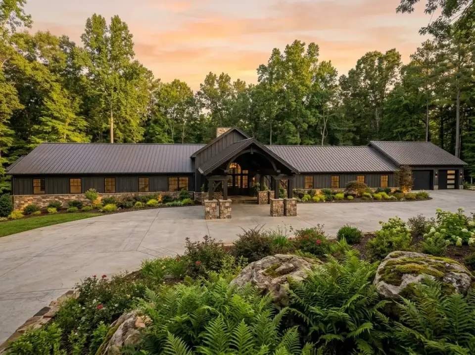 Dark woodland lodge barndominium in charcoal cladding blending into a forested backdrop