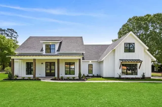White farmhouse facade with standing seam metal porch roof